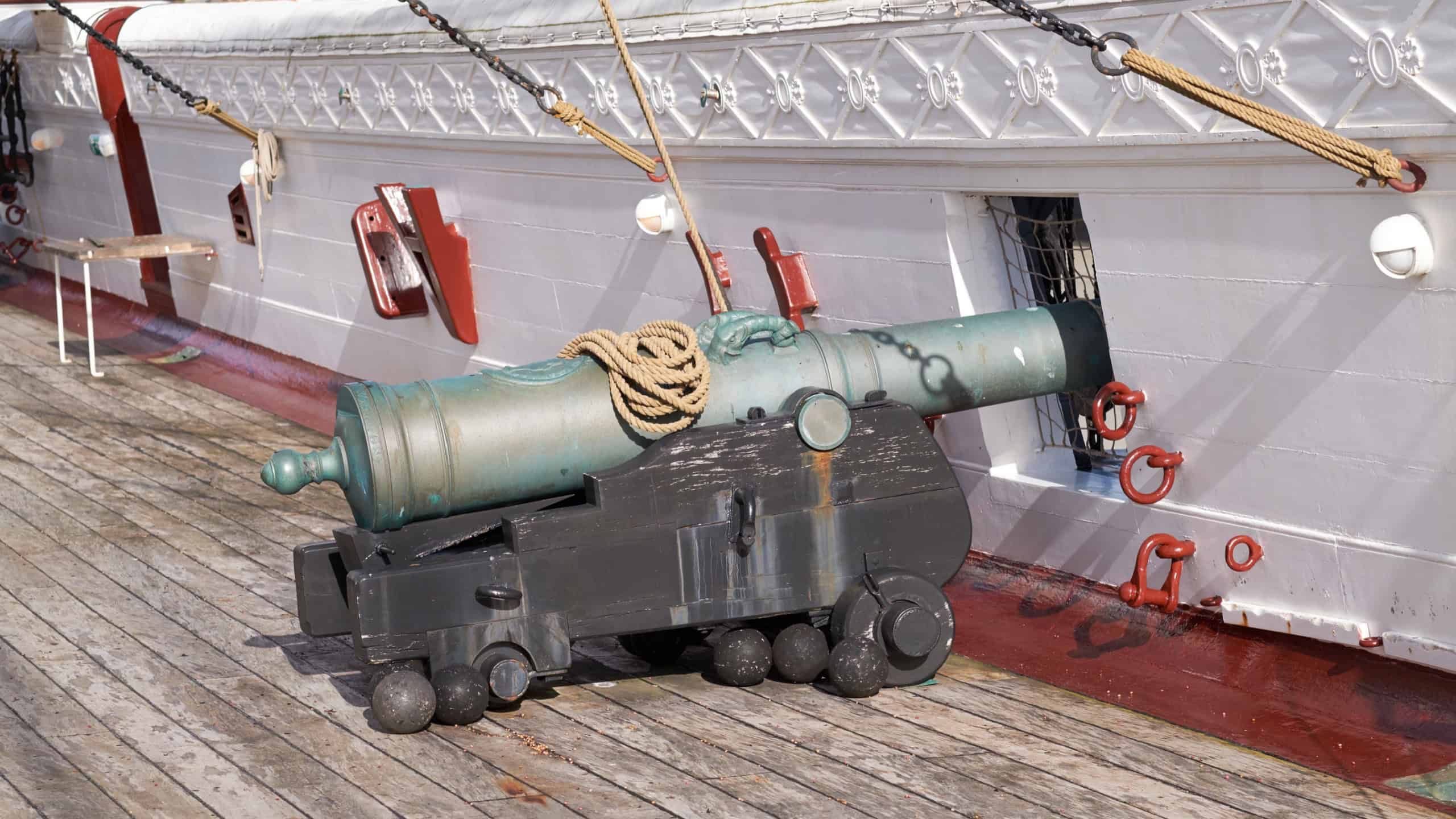 History, ship and cannon on deck for travel, sightseeing and landmark vessel in Denmark. Sailboat, museum and architecture with war gun for tourist attraction, exhibition and transportation on ocean