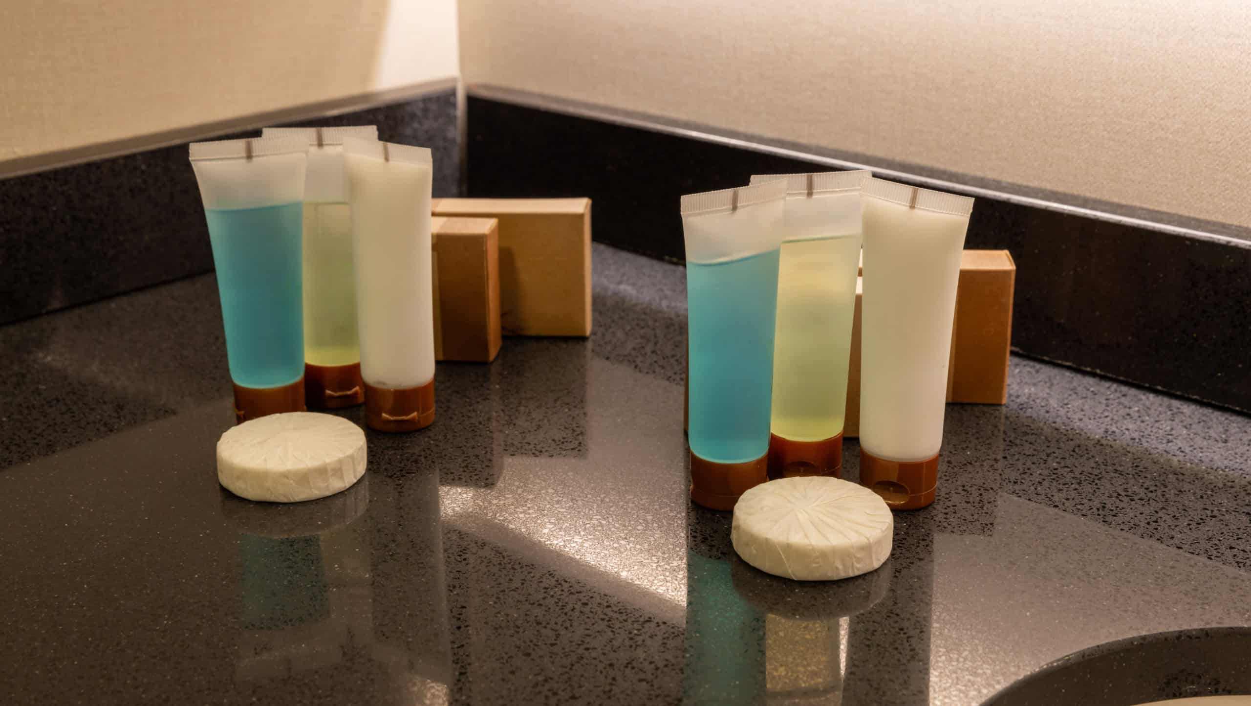 soap shower gel and shampoo on bathroom counter in hotel bathroom