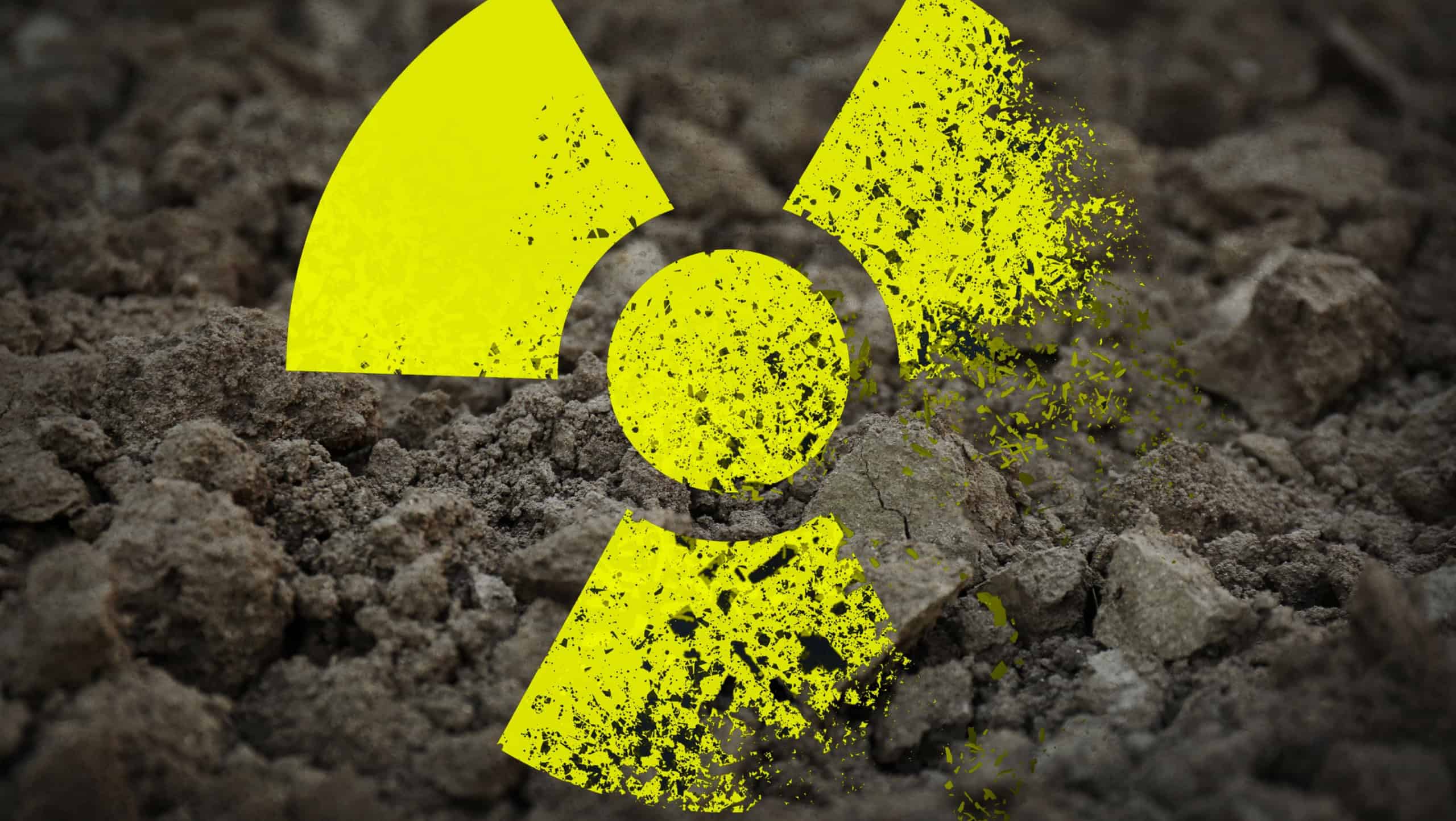 Yellow radioactive sign on soil, closeup. Radiological pollution