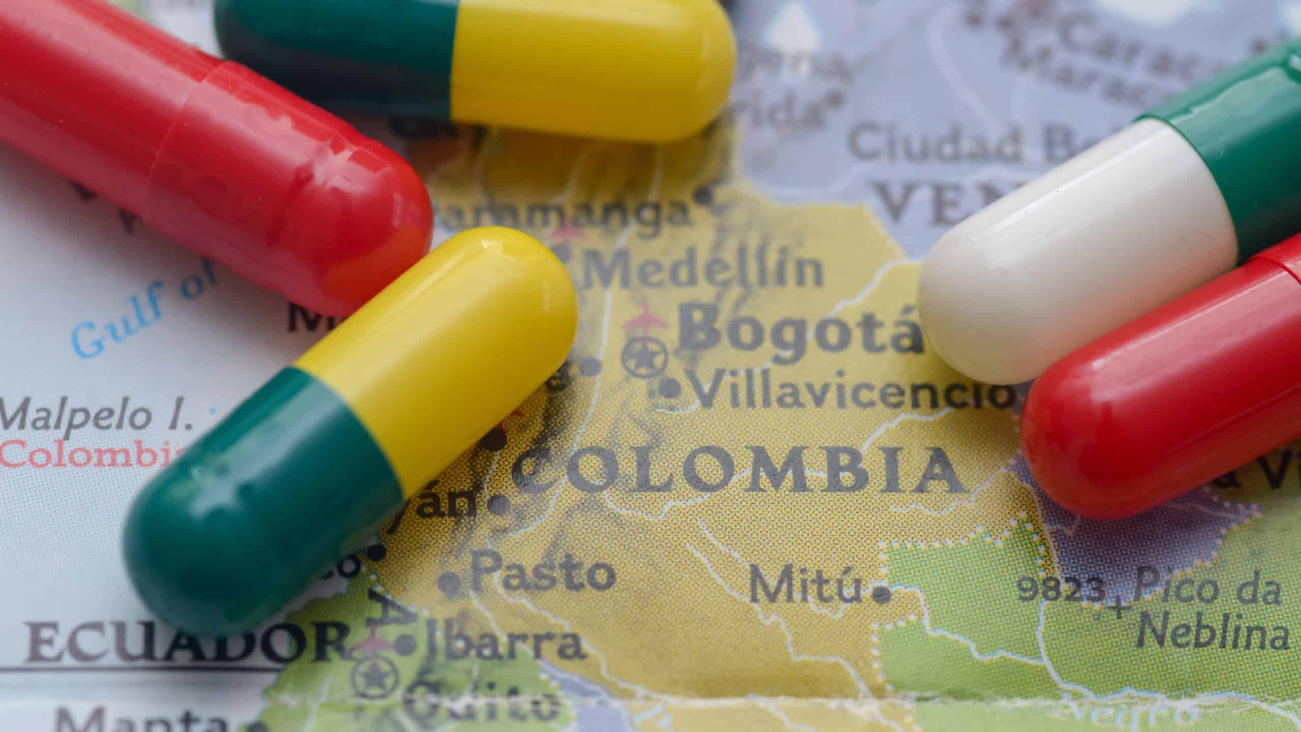 Colorful Capsules Scattered Over Map of Colombia Depicting Drug Trafficking Crisis