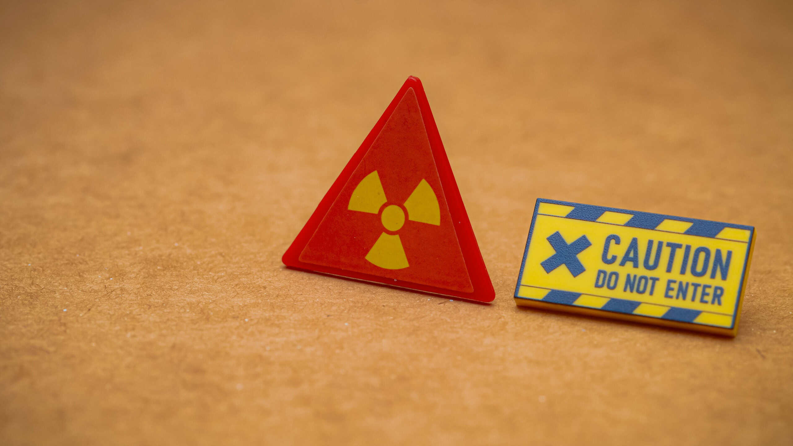 A radiation symbol and a "CAUTION DO NOT ENTER" sign create a clear warning for a high-risk, restricted area.