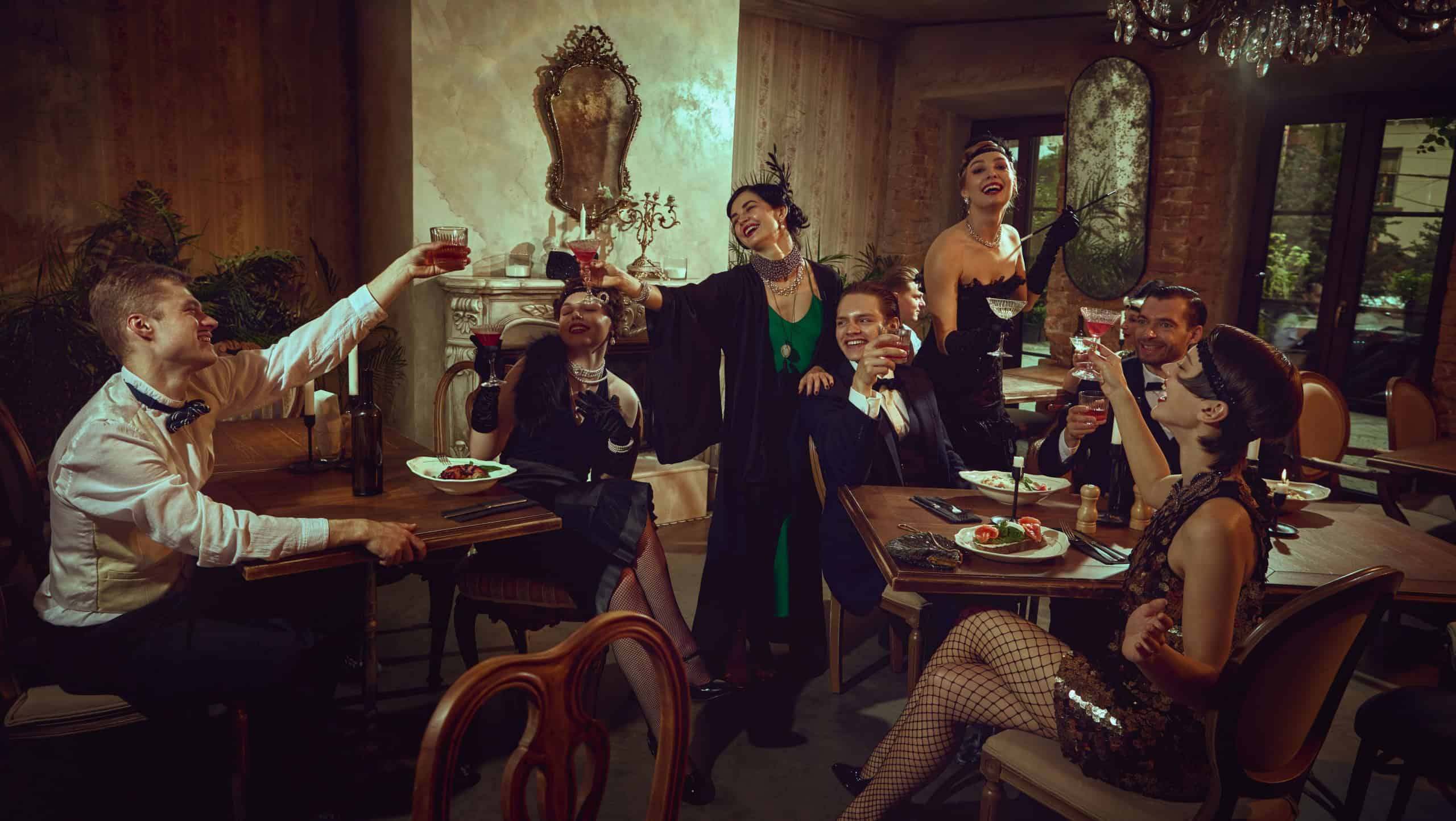 Joyful vintage celebration with friends raising glasses in warm interior. Concept of holiday marketing, gala dinner promo, themed party creatives, premium beverage ads, event agency materials.