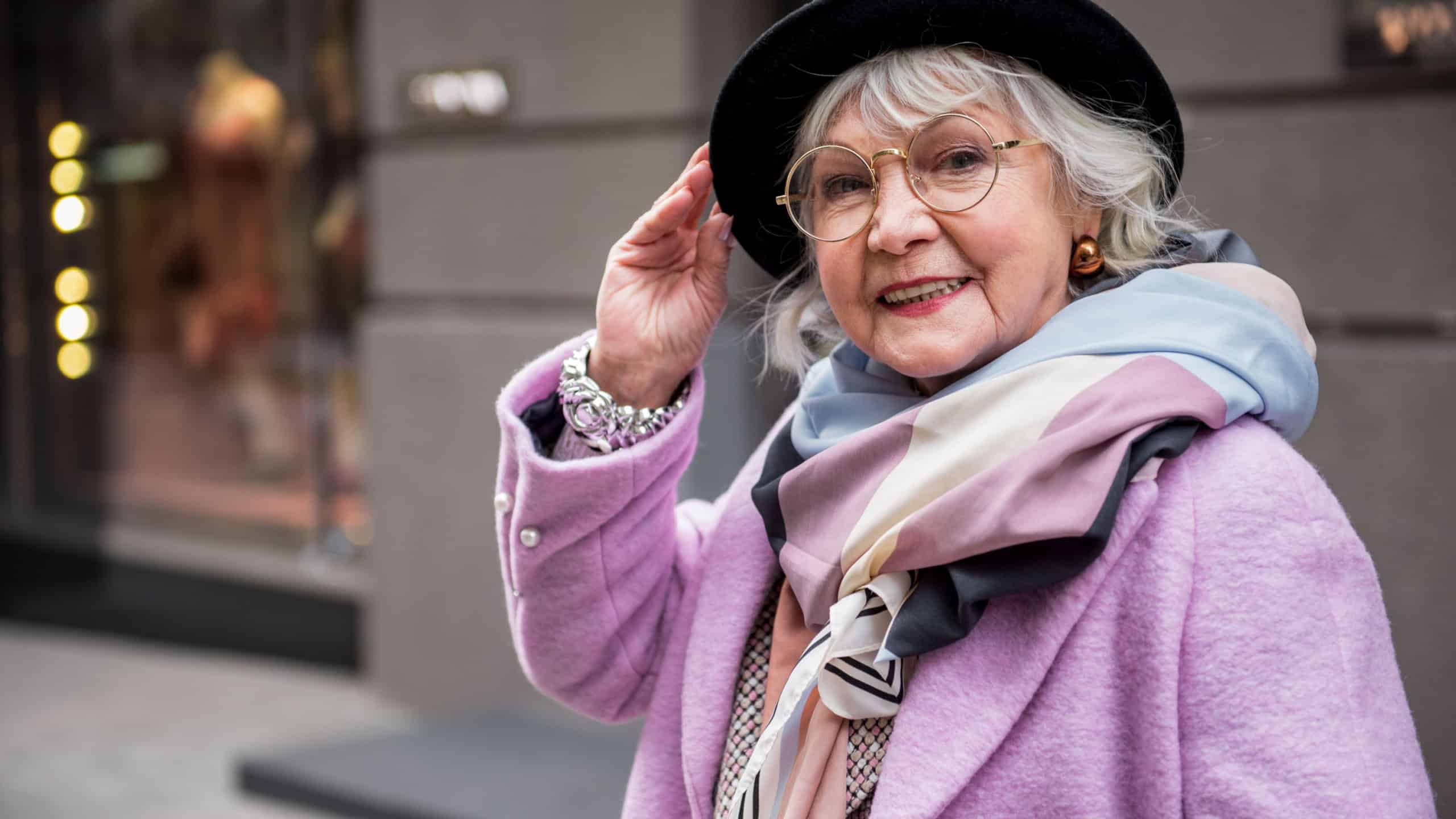 Joyful senior lady standing in fashionable clothing