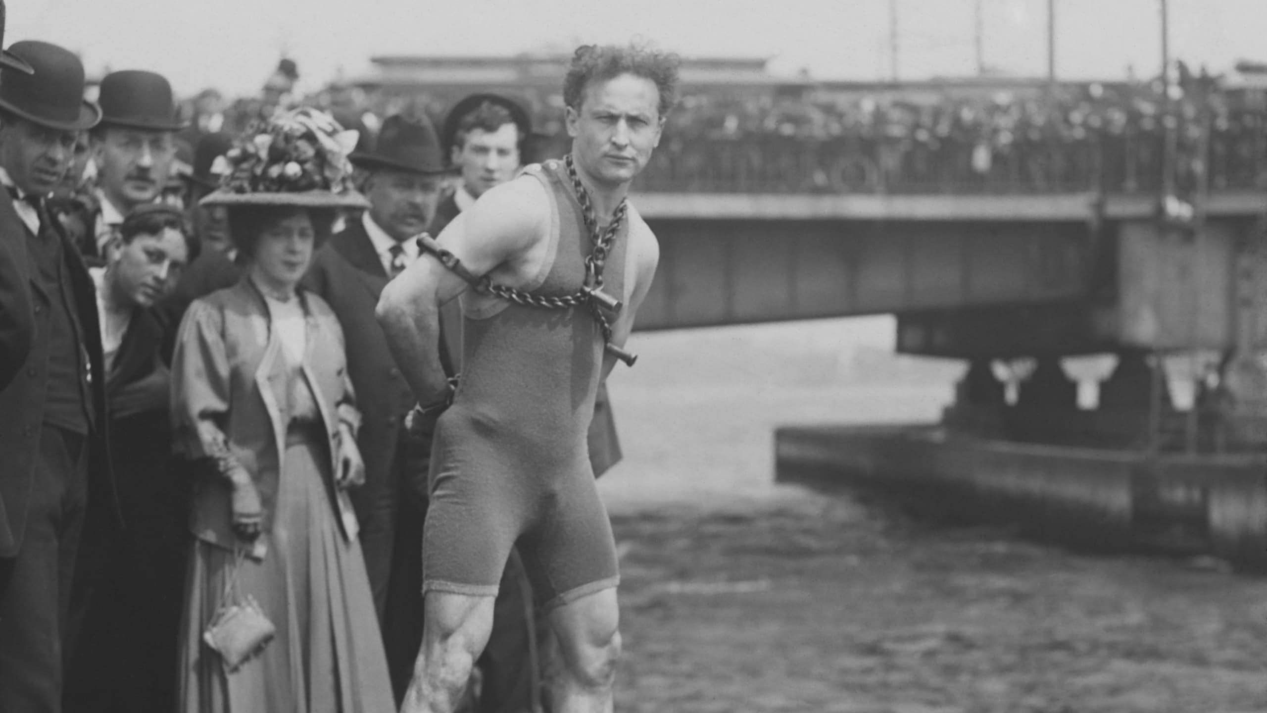 Harry Houdini jumps 30 feet from Harvard Bridge locked up in chains, April 30, 1908. Boston, Massachusetts. His hands were handcuffed and chained to a collar around his neck by a Boston policeman