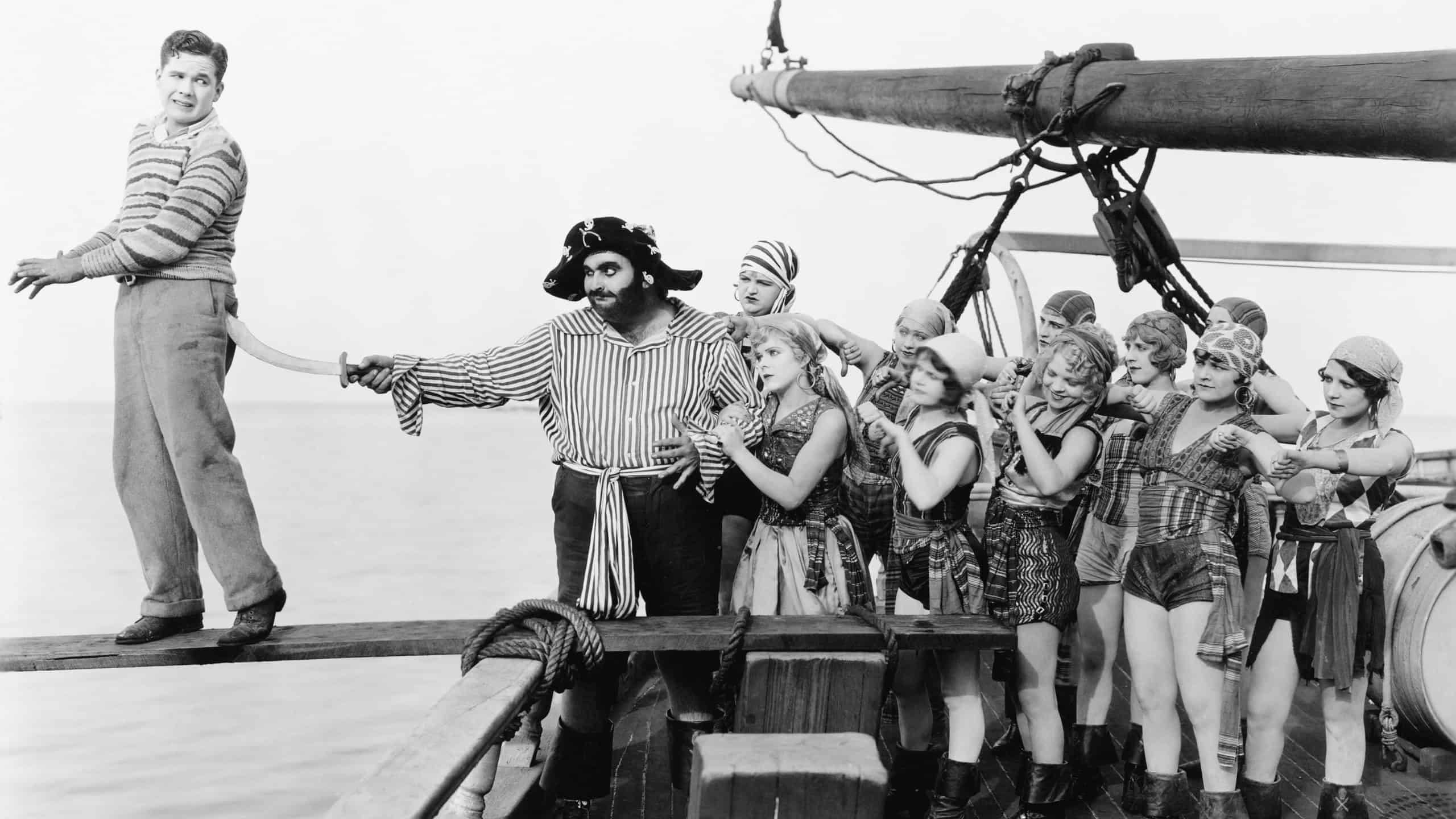 Group of pirates trying to push a young man over a plank