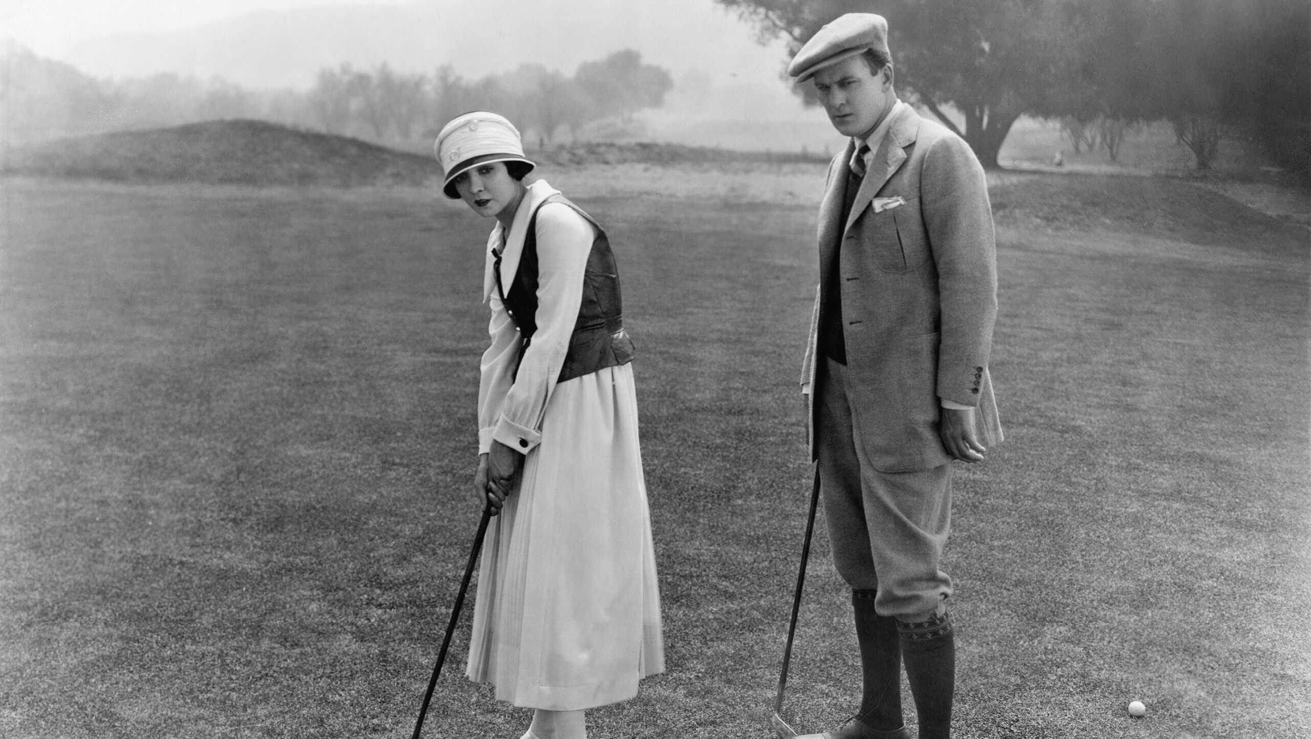 Profile of a couple playing golf in a golf course