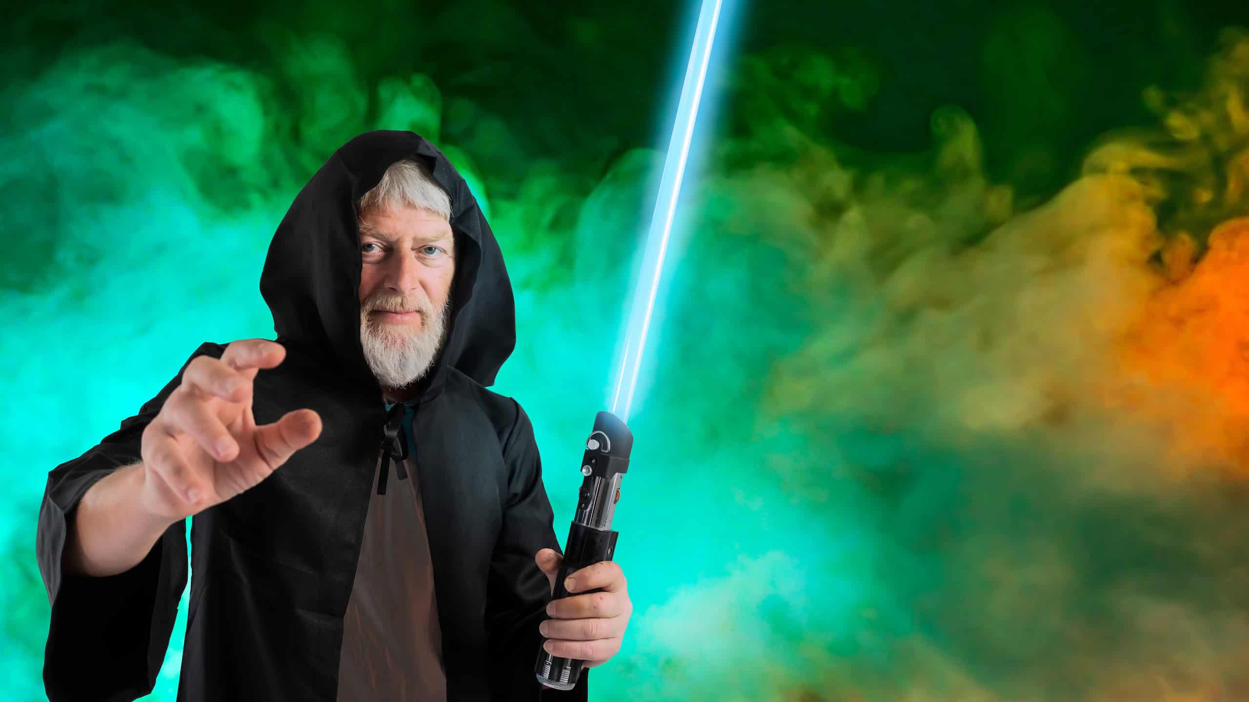 A man holds a laser lightsaber in a Halloween costume