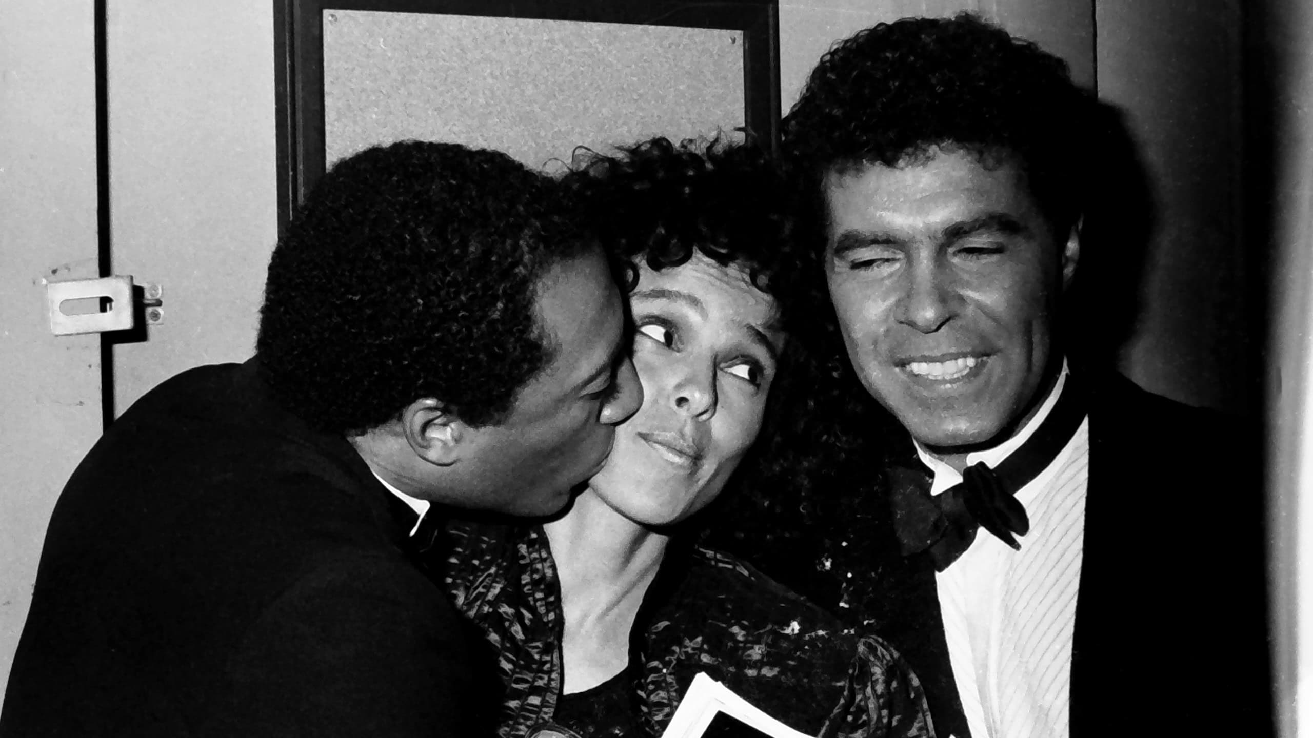 A black and white portrait of iconic actors Richard Pryor and Pam Grier side by side