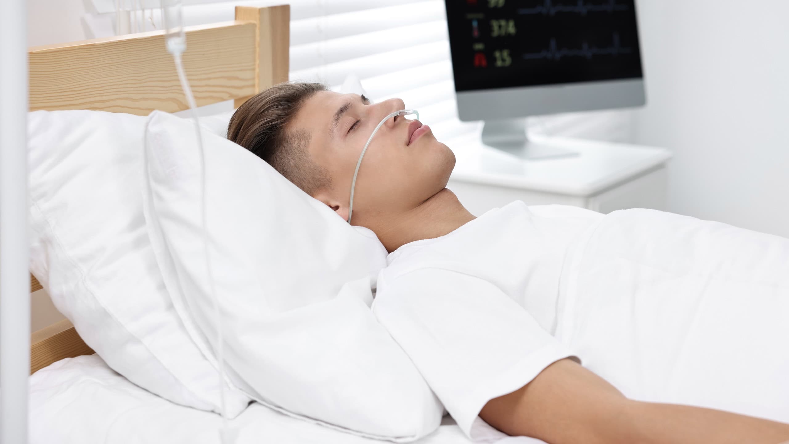 Coma patient. Young man sleeping in hospital bed