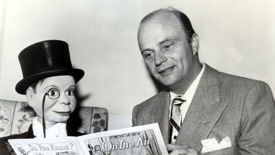 Photo of Edgar Bergen and Charlie McCarthy from NBC Radio. They are reading an NBC-produced comic book, On the Air, which told the story of what happens behind the scenes in radio broadcasts in a children's format.