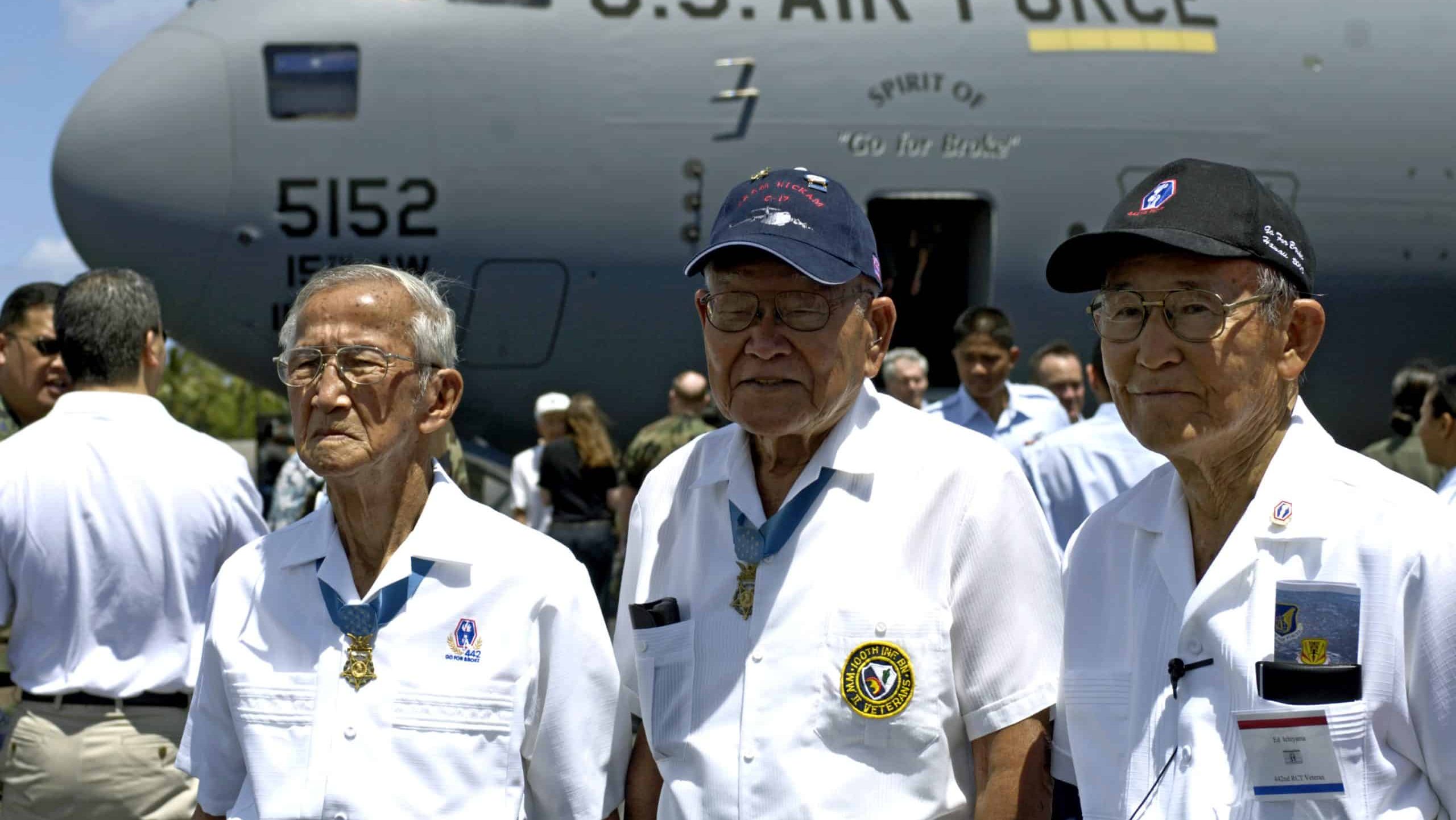 Barney Hajiro, Shizuya Hayashi and Ed Ichiyama pose in front of a C-17 Globemaster III named "The Spirit of 'Go for Broke'" during an arrival ceremony at Hickam Air Force Base, Hawaii,