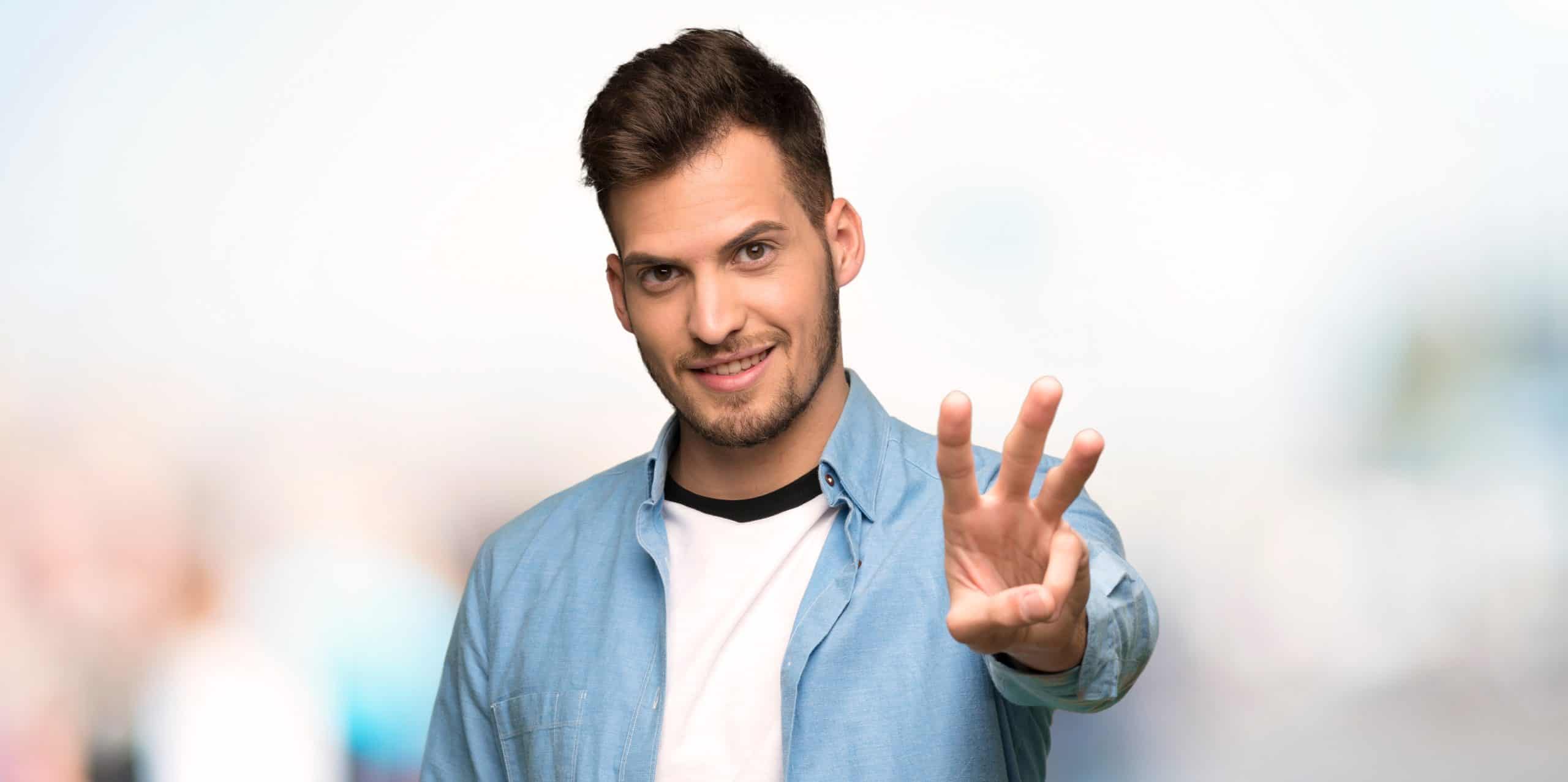 Handsome man happy and counting three with fingers at outdoors