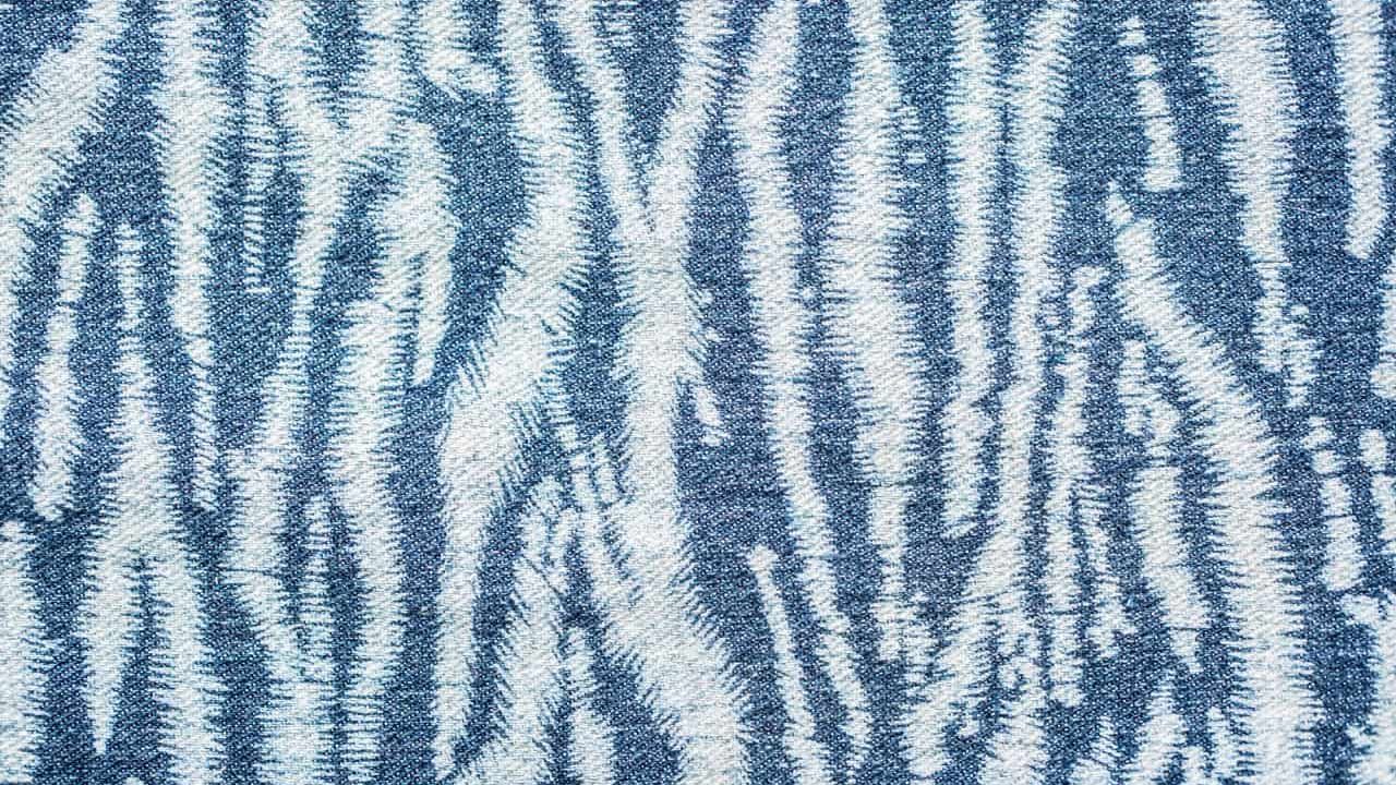 Jeans background. Denim fabric closeup. Textures of clothing fabric with fashion embroidery blue colors. Copy space for text. Fashion & Style.