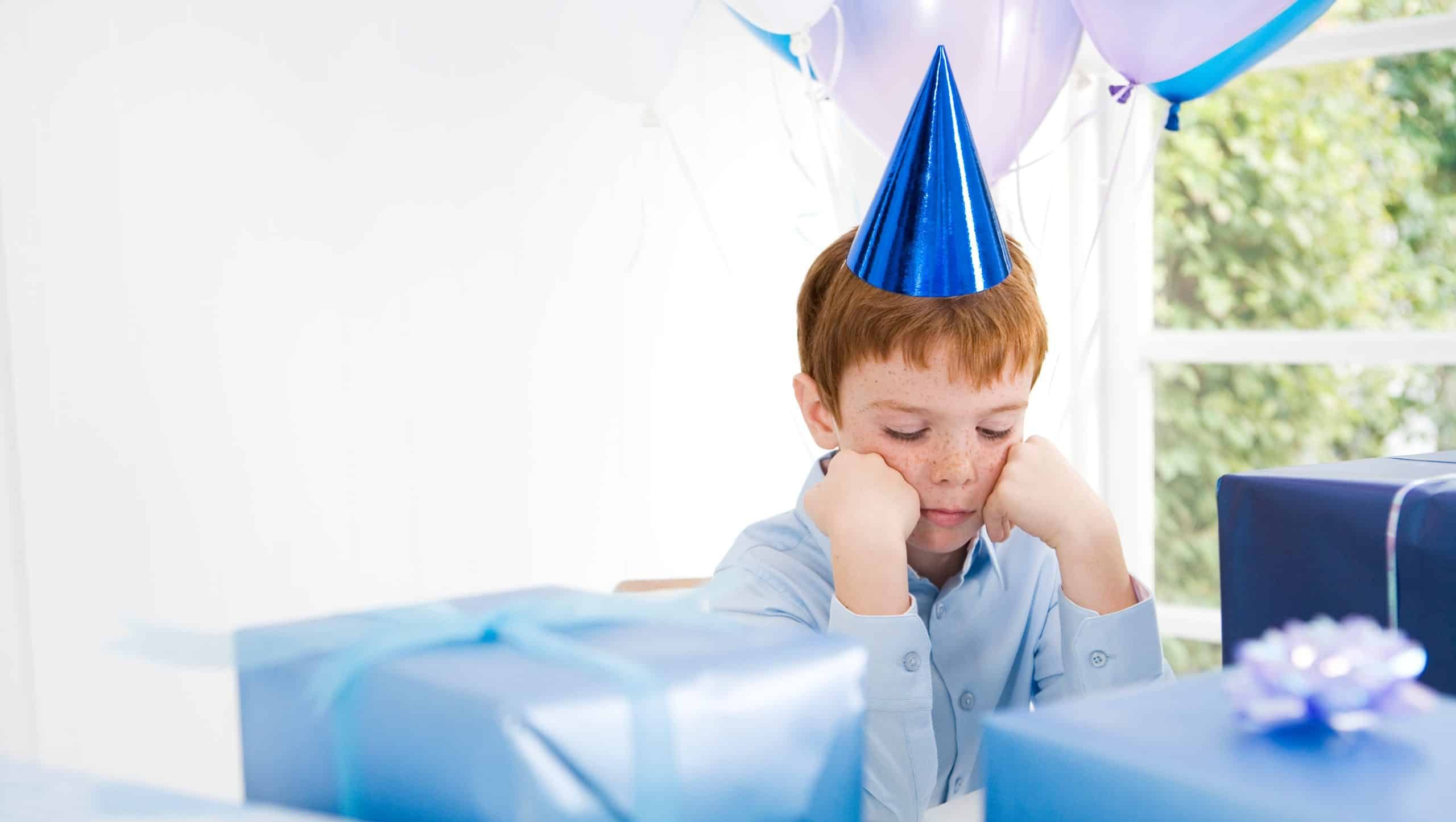boy looking sad at birthday party