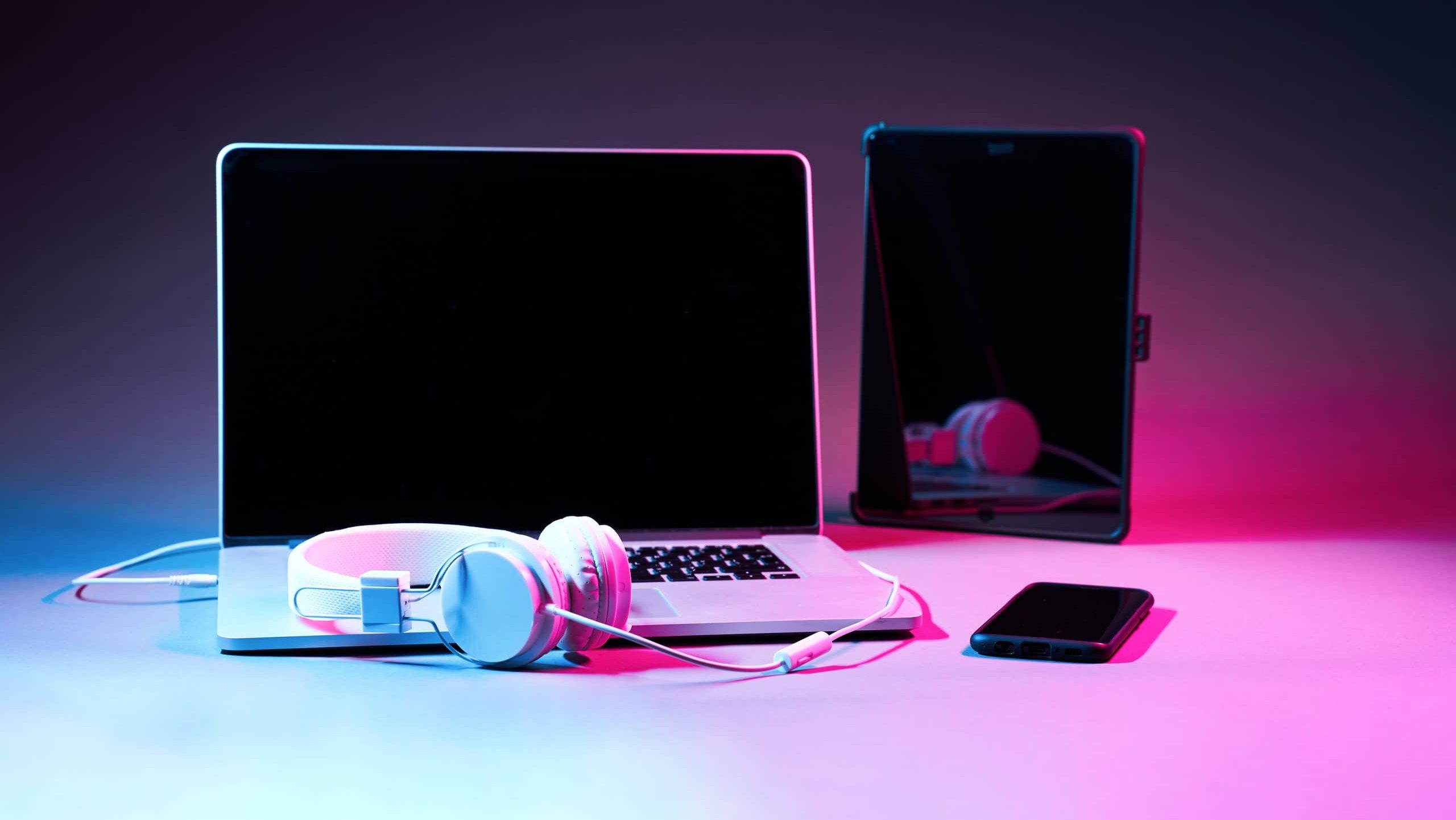 Computer laptop, smart phone, tablet, touch pad and headphones in neon color