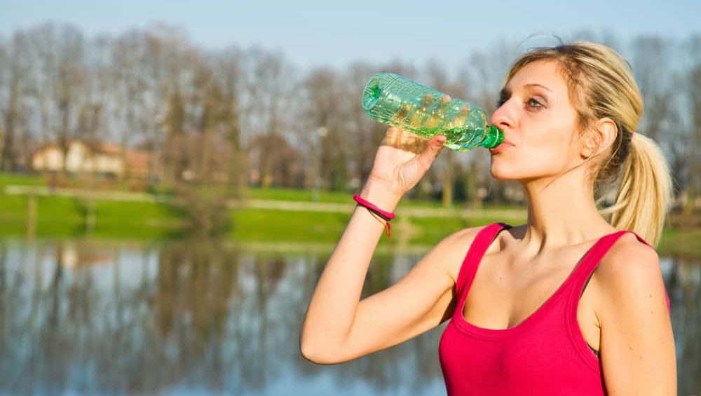 woman drinking water from bottle after fitness sport exercise
