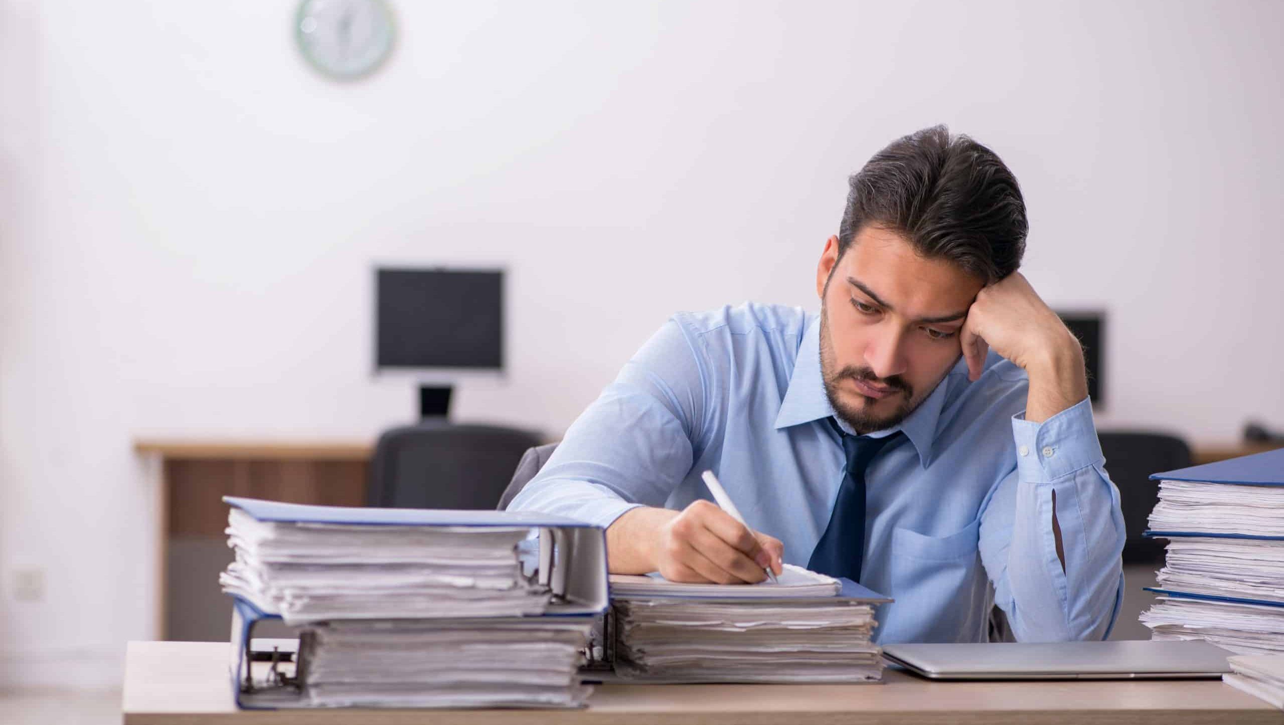 Young male employee and too much work in the office