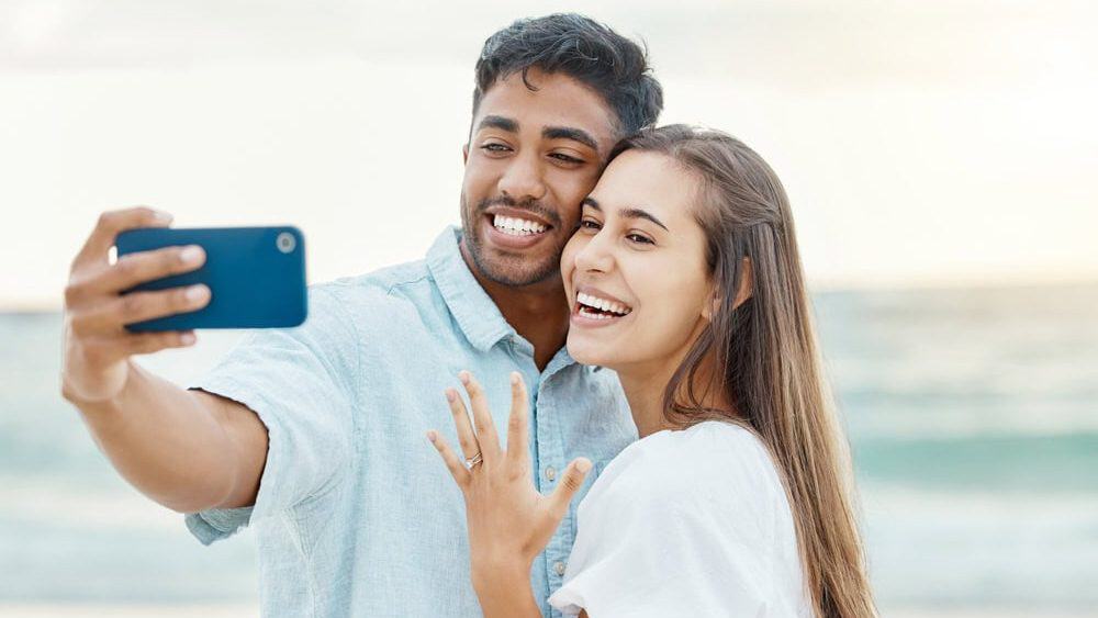 Love,,Beach,And,Couple,After,Their,Engagement,Taking,A,Selfie