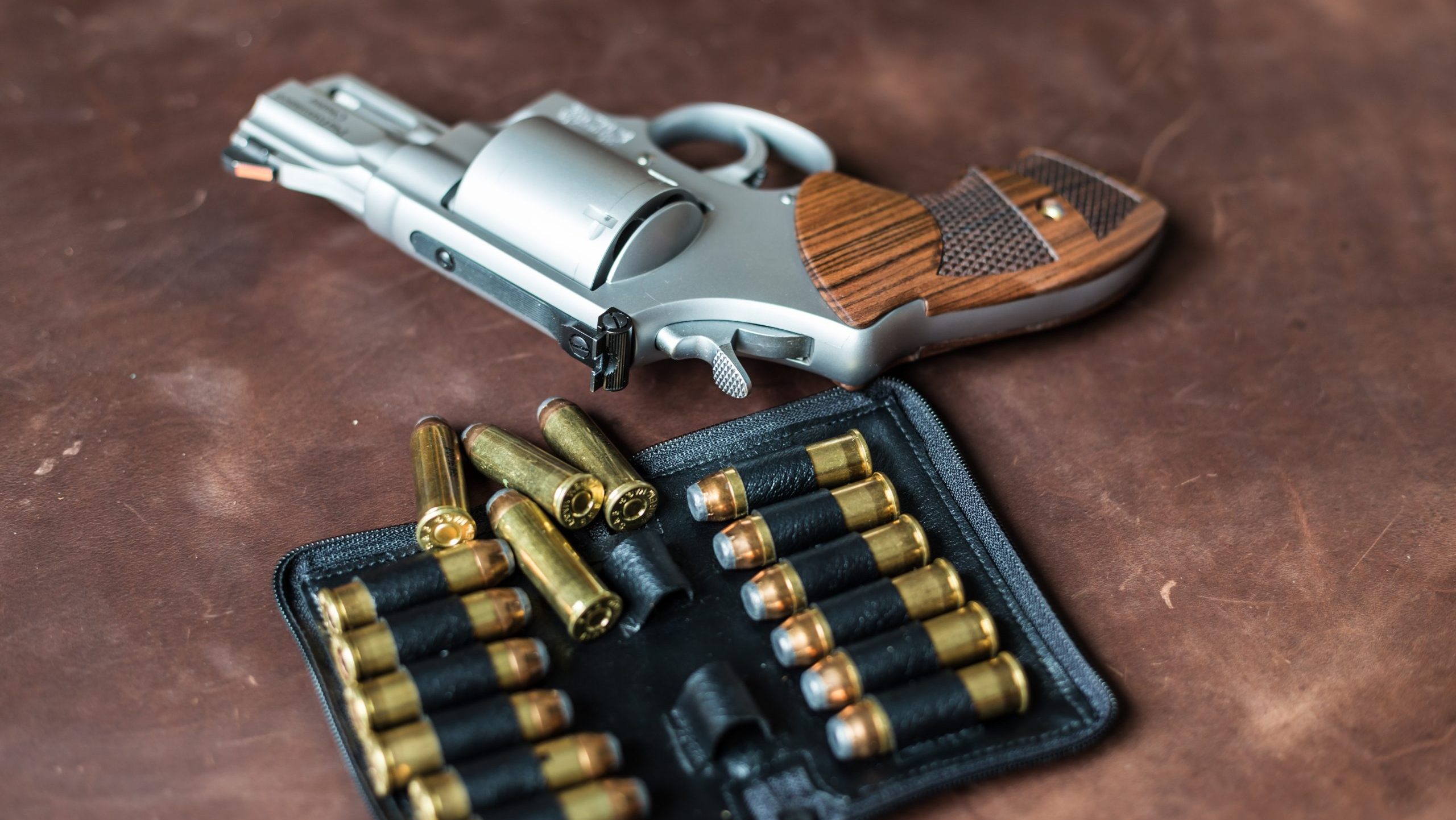 Hand revolver gun .44 magnum with bullet on leather self defence concept