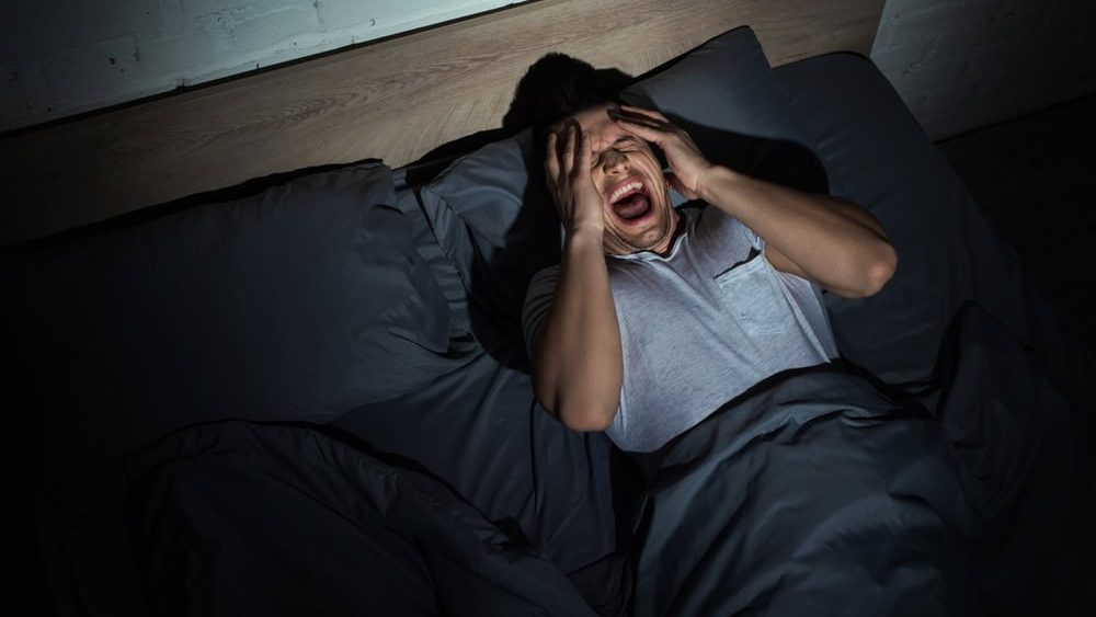 Top,View,Of,Young,Man,Screaming,While,Having,Nightmares,And