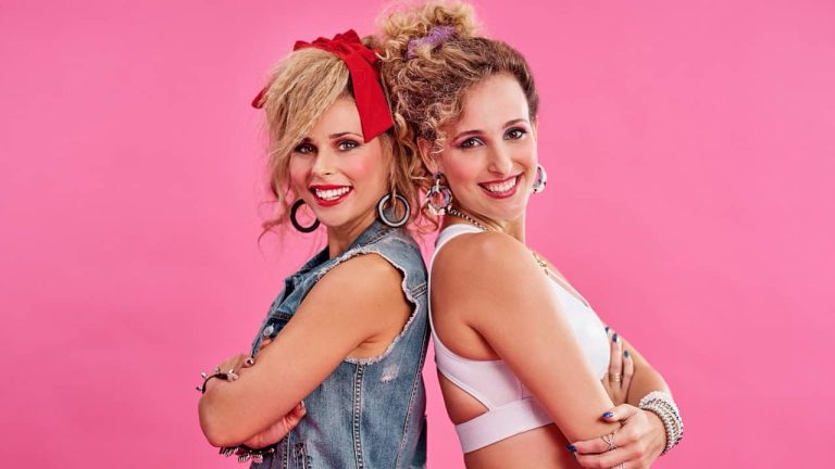 Friends, 80s fashion and portrait of happy women in studio together with smile, vintage theme and pink background. Friendship, fun and woman with friend, retro clothes and hairstyle with jewellery.
