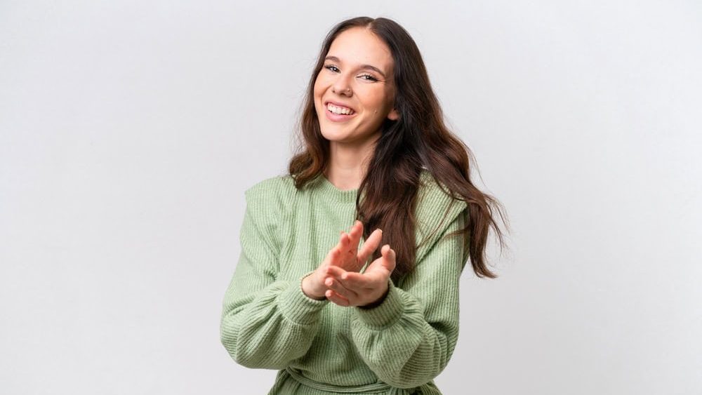 Young caucasian woman isolated on white background applauding after presentation in a conference