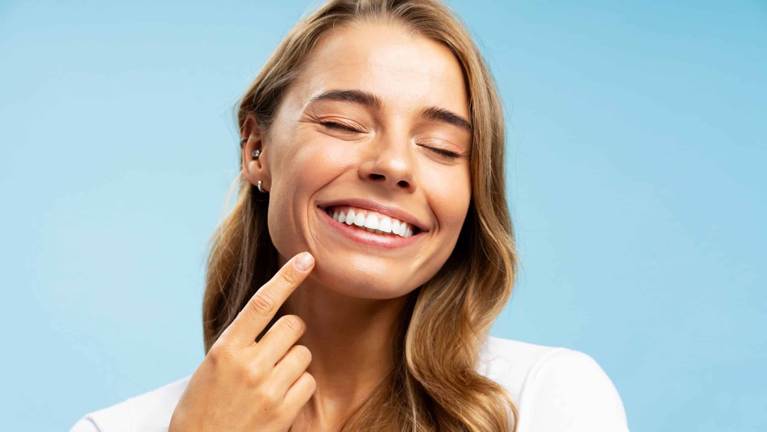 Closeup,Portrait,Smiling,Beautiful,Woman,Pointing,Finger,On,White,Teeth