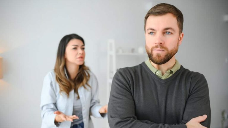 Family quarrel, man and woman sitting on sofa at home. angry woman yells at her husband.