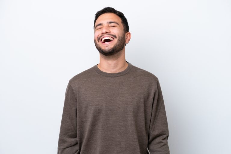 Young Brazilian man isolated on white background laughing