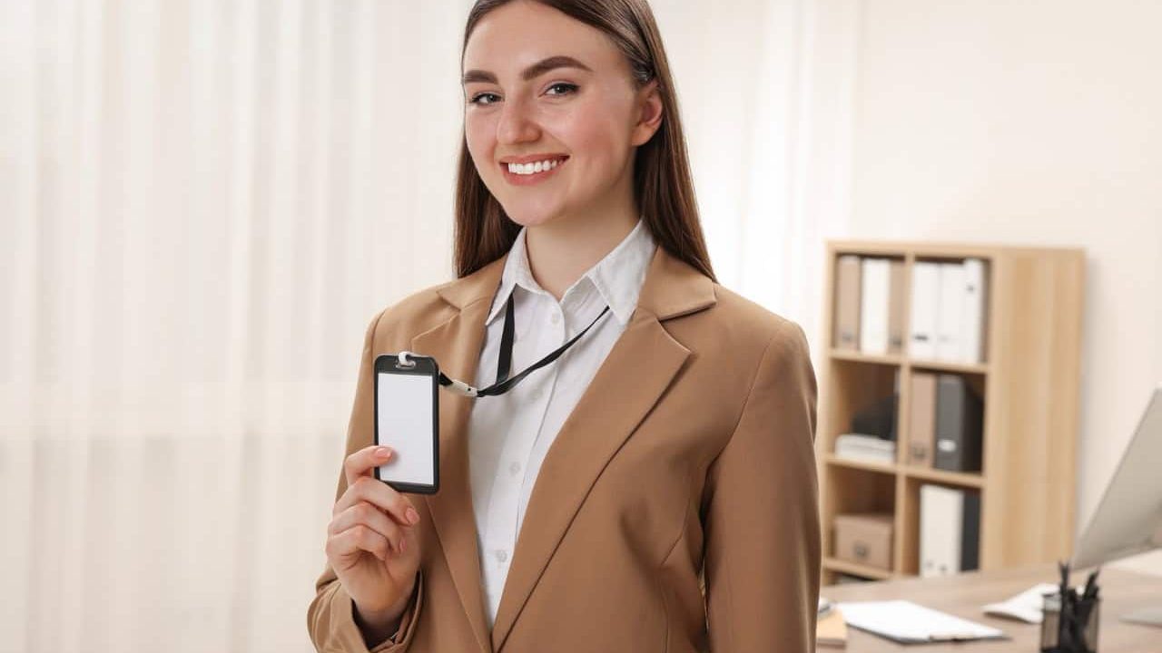 Happy woman with blank badge in office