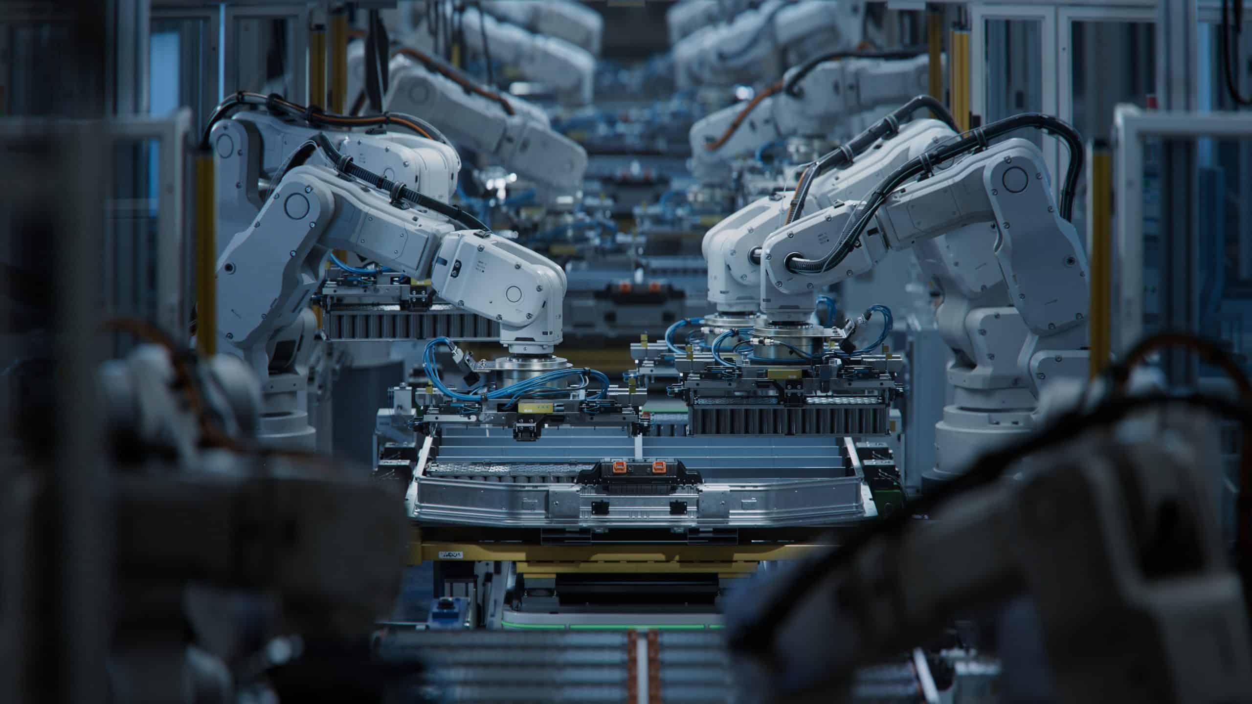 Row of White Robotic Arms at Automated Production Line at Factory. Electric Car Manufacturing Line Inside Automotive Smart Factory. Industrial Robot Arms Assemble Lithium-Ion EV Battery Pack.