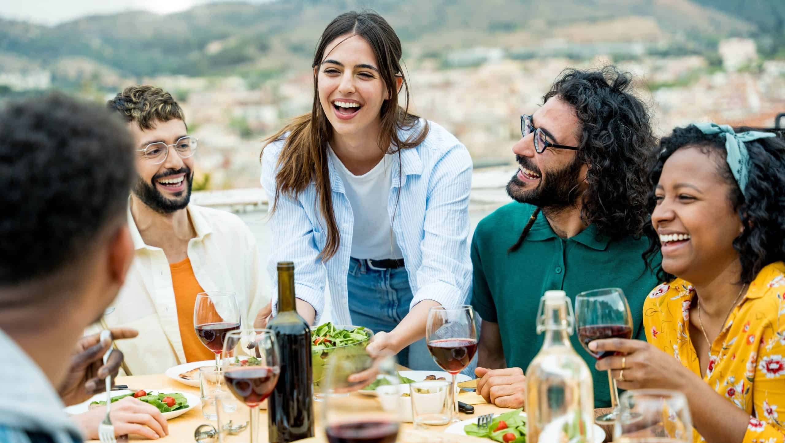 Happy,Friends,Dining,And,Drinking,Red,Wine,Glasses,On,Balcony