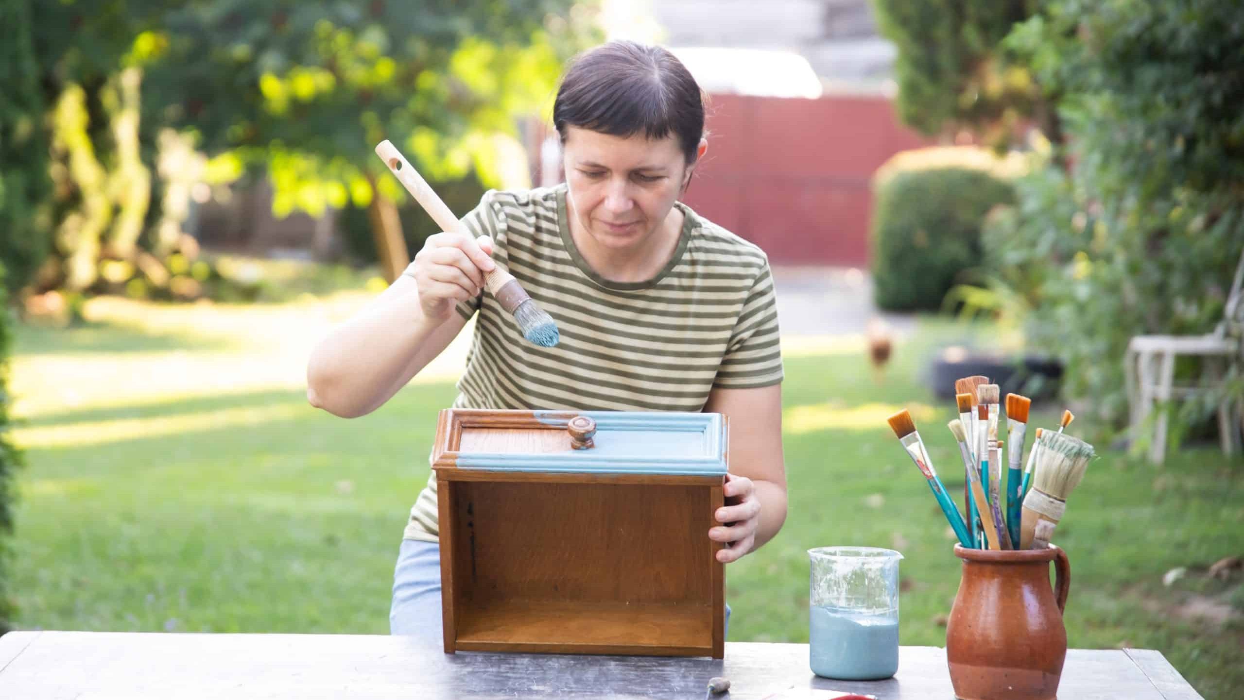 Mid,Woman,Painting,Furniture,Outdoors,At,Home,,Relocation,And,Diy