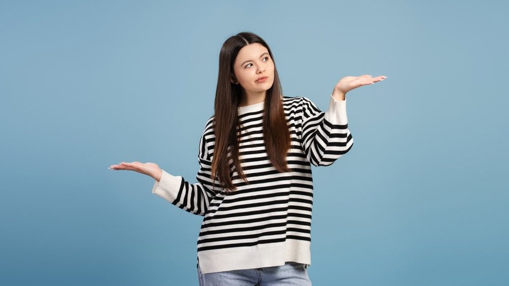 Attractive,Teen,Girl,Showing,Scales,With,Hands,,Comparing,Two,Products,