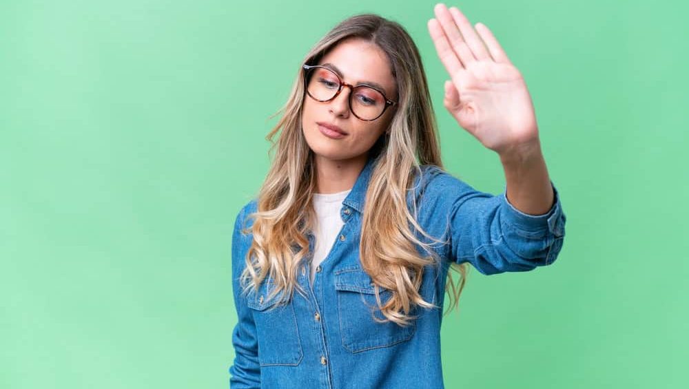 Young Uruguayan woman over isolated background making stop gesture and disappointed