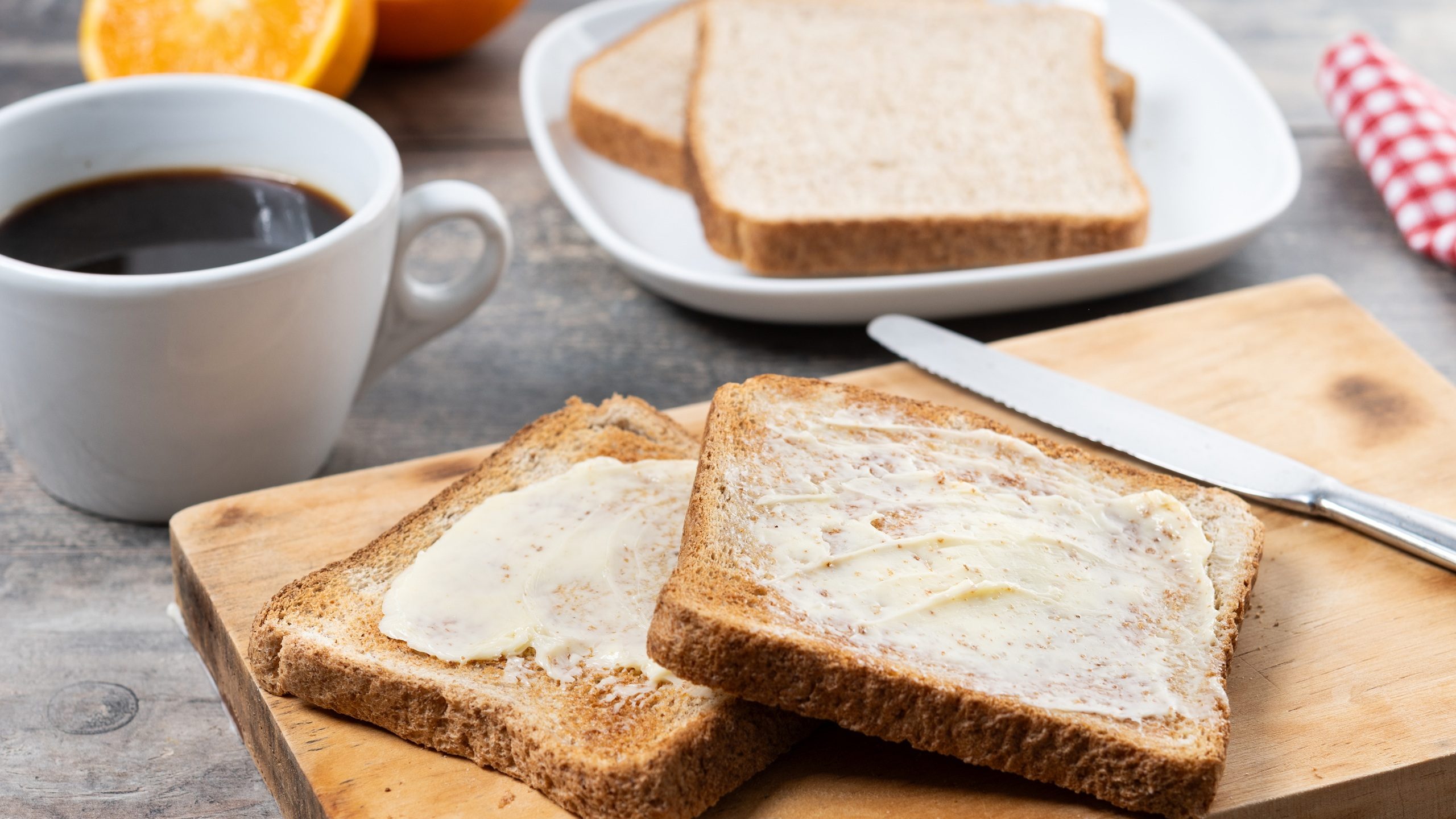 Sliced fresh bread and butter on wooden table