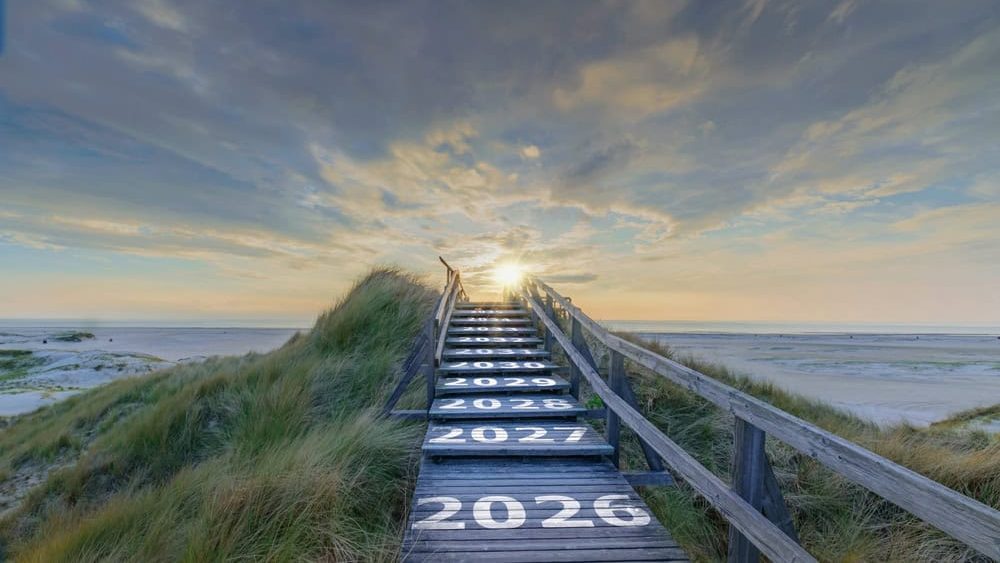 Text 2026, 2027 up to 2035 written on wooden stairway leading over coastal dunes towards sunrise, symbol path into future. Stairway into future, timeline path through coastal dunes. Amrum 2026.