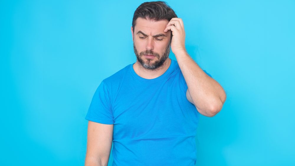 Handsome man standing over yellow background with hand on chin thinking about question. Pensive expression. Thoughtful face. Doubt concept. Thinking question, thoughtful about confusing idea.