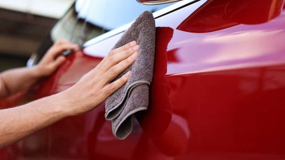 Man,Wiping,Car,With,Grey,Microfiber,Rag,Outdoors,,Closeup