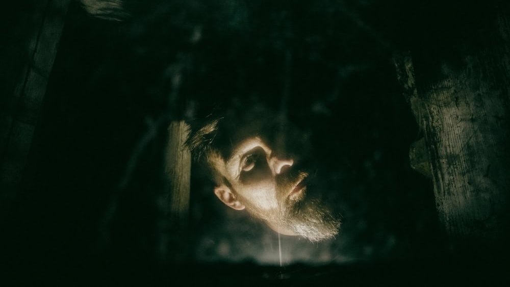 scary man behind window with spider nets at night Halloween horror background