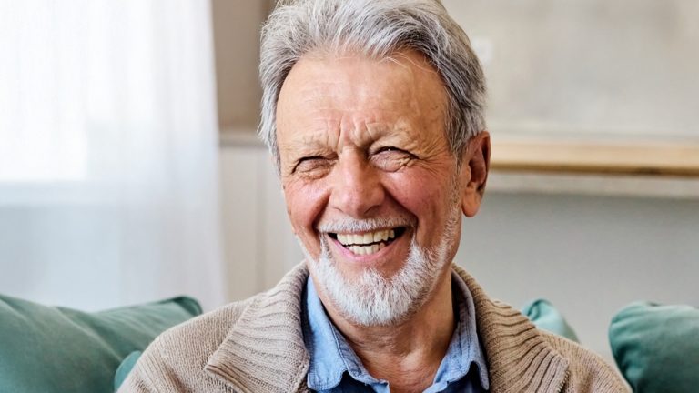 Portrait of a happy senior elderly man posing at home