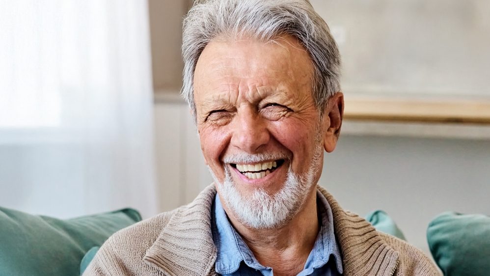 Portrait of a happy senior elderly man posing at home