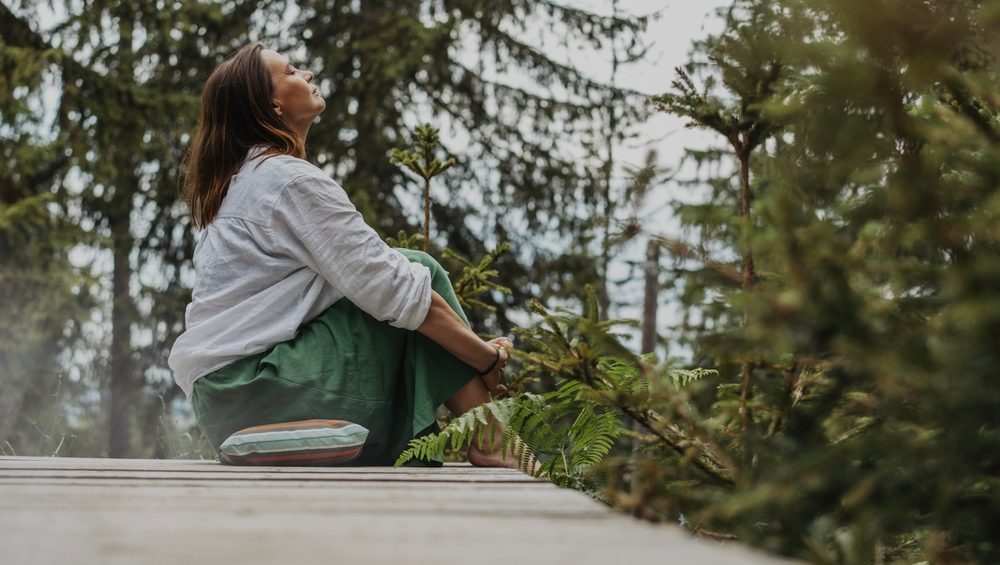 Breathing and smile for fresh air in nature, mature woman relaxing outdoor