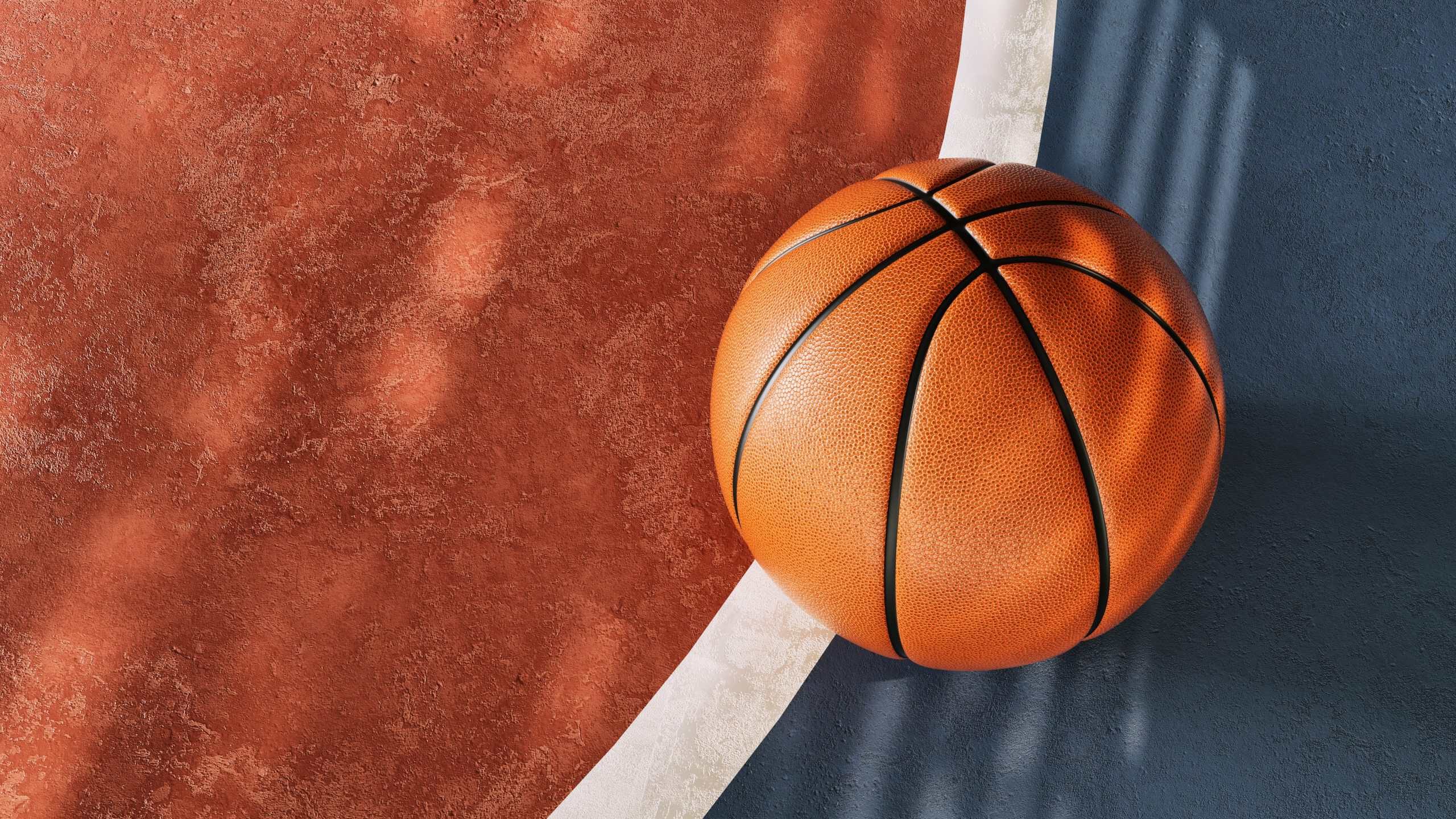 Classic orange basketball placed on textured court brown and blue surface outdoor sport minimal concept