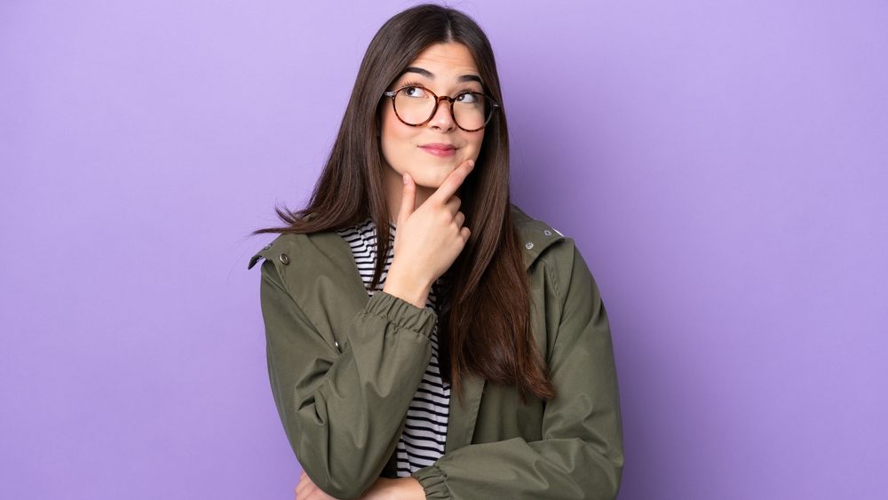 Young Brazilian woman isolated on purple background thinking an idea while looking up