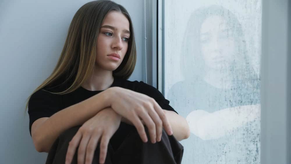 Depressed,Teenage,Girl,Near,Window,At,Home