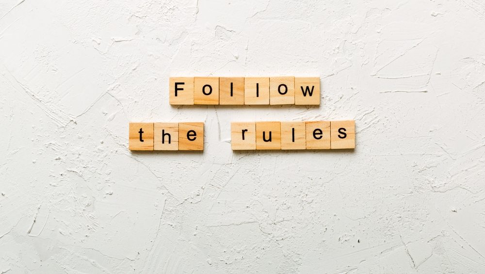 Follow The Rules word written on wood block. Follow The Rules text on table, concept.