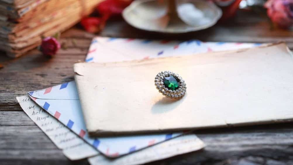A,Diamond,Brooch,With,A,Large,Emerald,At,Its,Center.