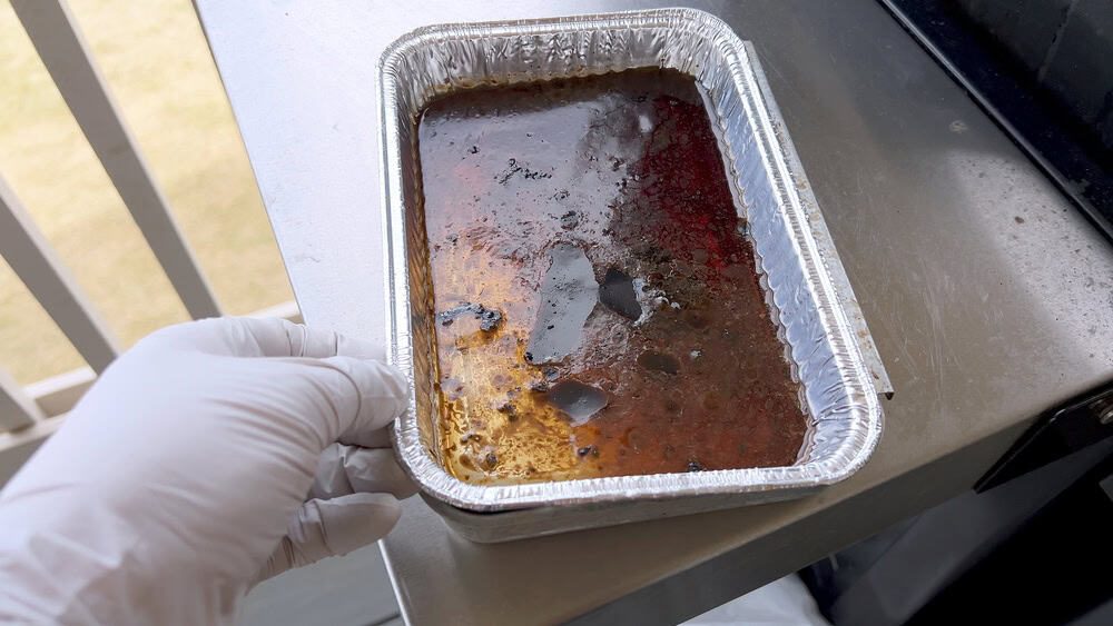 A,White-gloved,Hand,Holds,A,Disposable,Aluminum,Drip,Tray,Containing