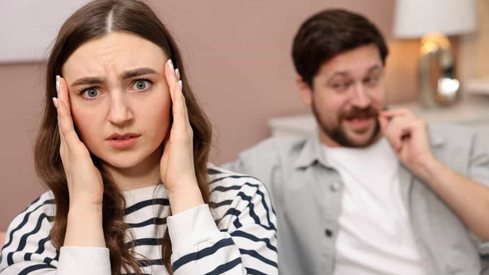 Embarrassed woman ignoring flirting man at home, selective focus